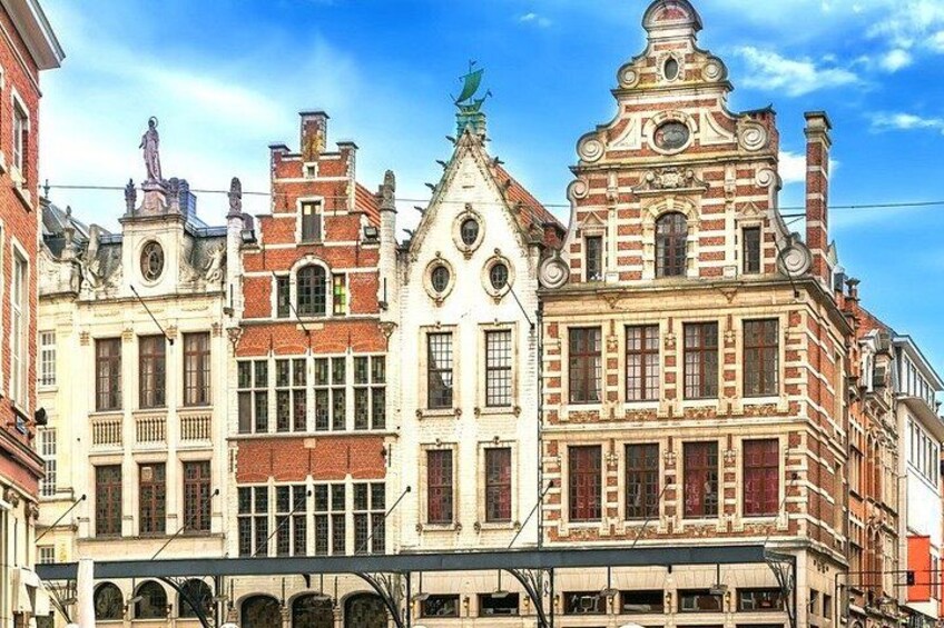 A row of historic buildings with distinct architectural styles, including a red brick facade and ornate details. 4
