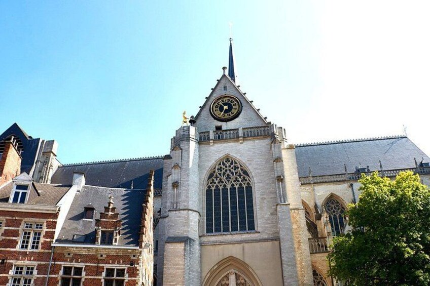A historic church with a clock tower, arched windows, and a pointed spire. 2