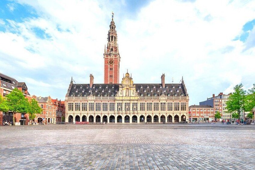 A historic building with a clock tower, a large open square, and surrounding traditional architecture. 5