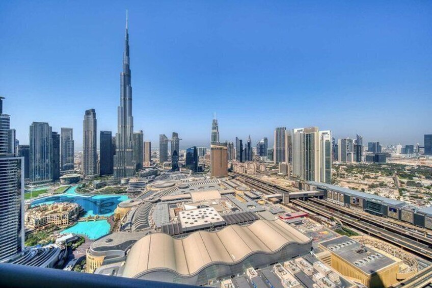 A cityscape with a prominent skyscraper, a large swimming pool, and an extensive transportation network. 3