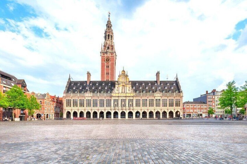 A historic building with a clock tower, a large open square, and surrounding traditional architecture. 5