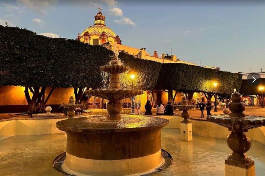 A fountain, a dome-shaped building, and a tree-lined square. 1