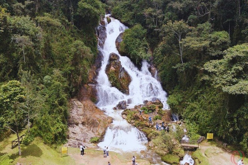 A multi-tiered waterfall surrounded by dense forest. 1