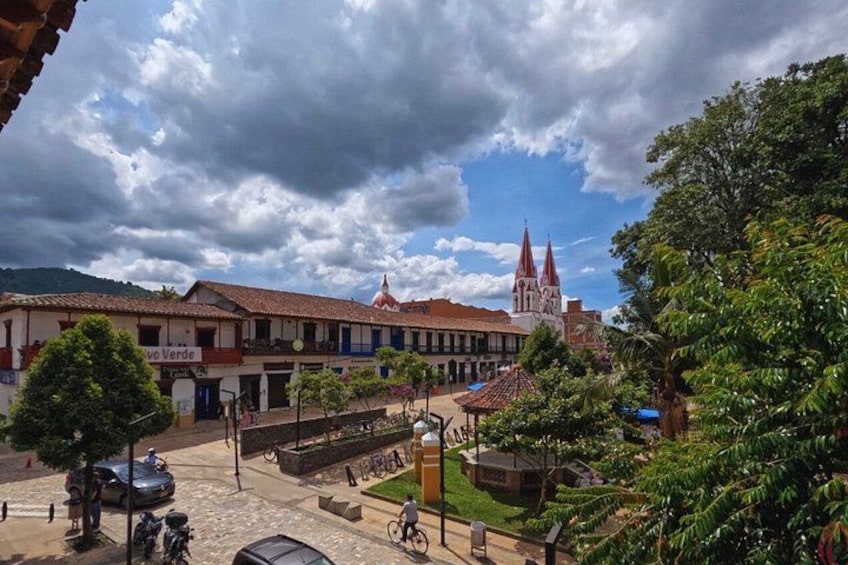 A town square with buildings, a church with a red roof, and a clear sky. 3