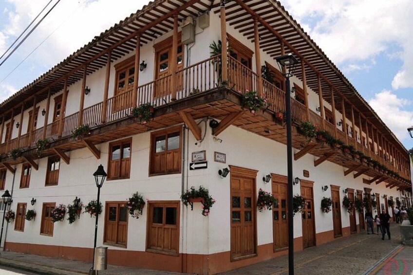 A traditional building with wooden balconies, white walls, and wooden doors. 4
