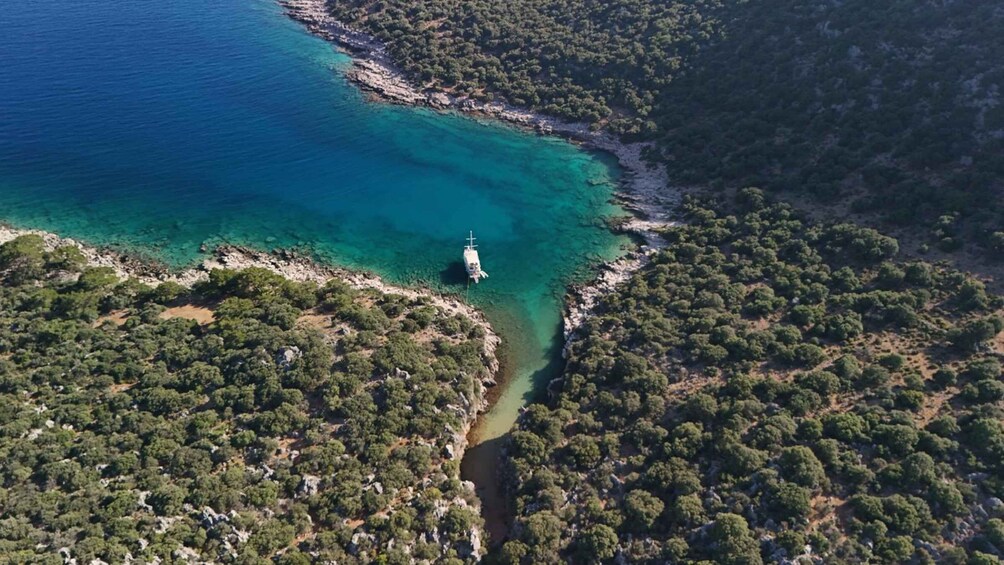 An aerial view of a coastal area with clear turquoise waters, a narrow waterway, and dense green vegetation. 5