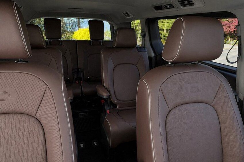 A car's interior with brown leather seats and a central console. 2