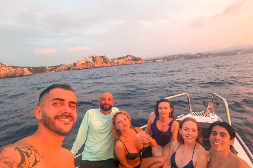 A group of people on a boat with a rocky coastline in the background. 3