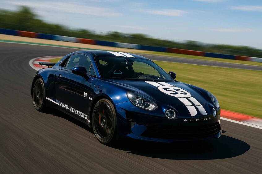 A blue sports car with racing stripes on a track. 2