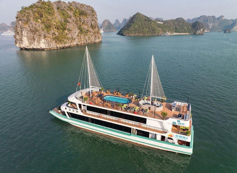 A large boat with a swimming pool and lounge areas, surrounded by water and islands. 1