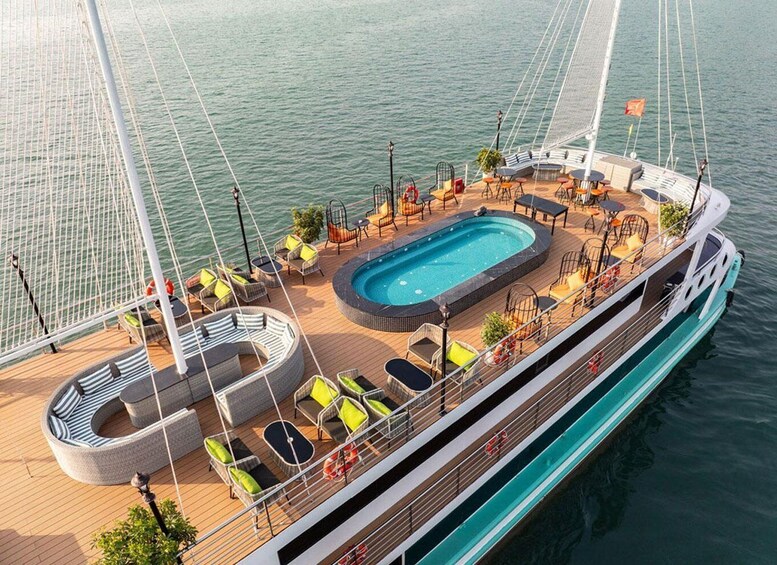 A yacht with a swimming pool, lounge chairs, and a deck area. 4