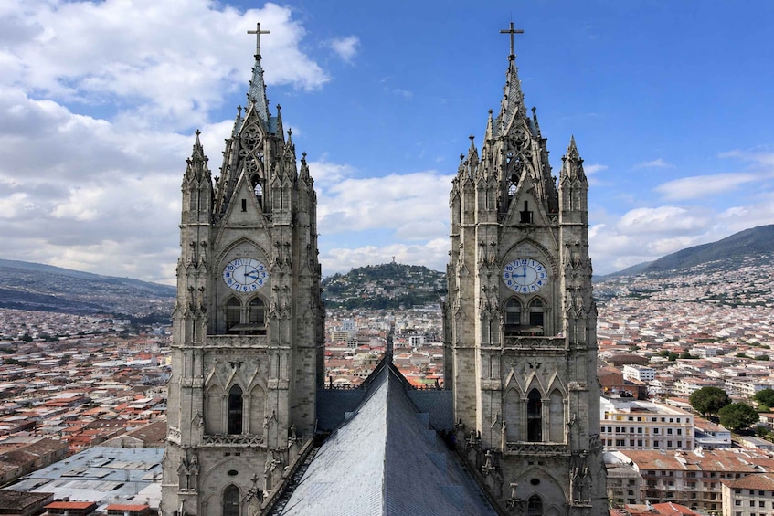 A cathedral with two towers, a clock, and a cityscape in the background. 2