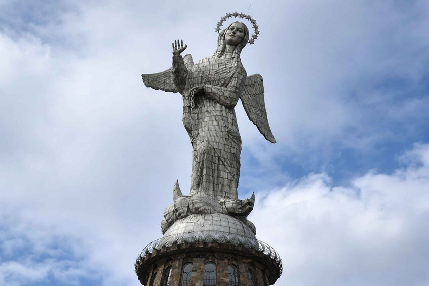 A statue of an angel with outstretched wings and a halo, standing on a circular base with a dome. 4