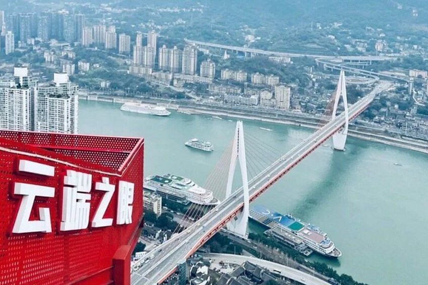 A large red building with Chinese characters, a modern bridge, and a river with boats. 2