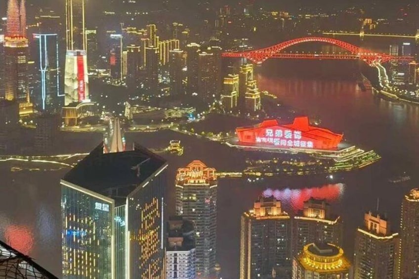 A cityscape at night with illuminated buildings, a prominent red bridge, and a traditional red building with Chinese characters. 3