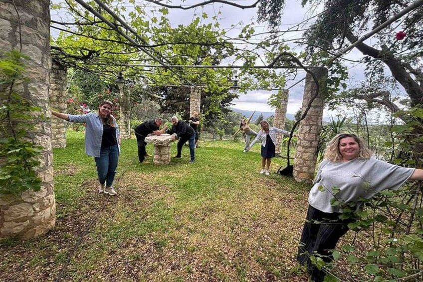 A group of people in an outdoor setting with stone structures and trees. 1