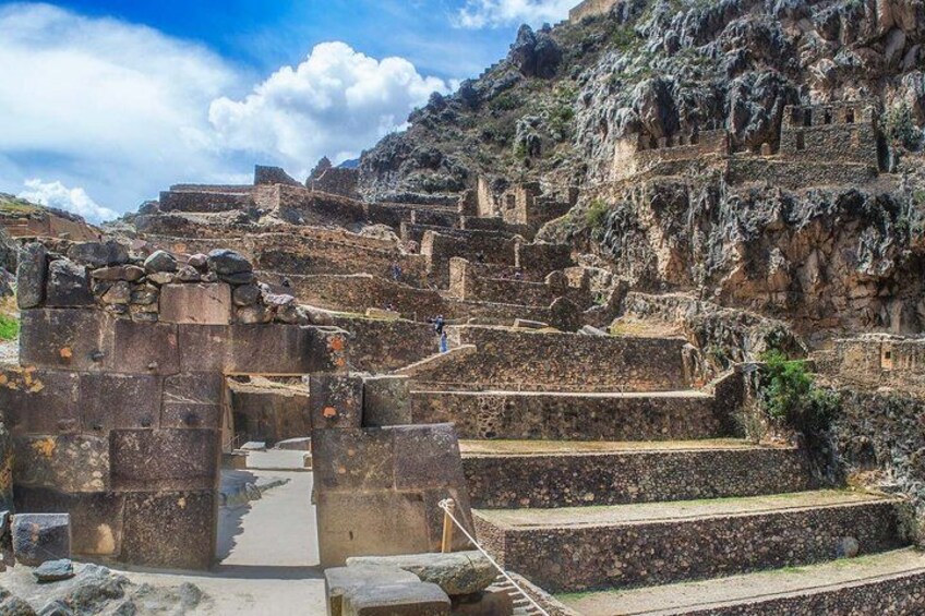 Ancient ruins with stone steps and walls, set against a mountainous backdrop. 2