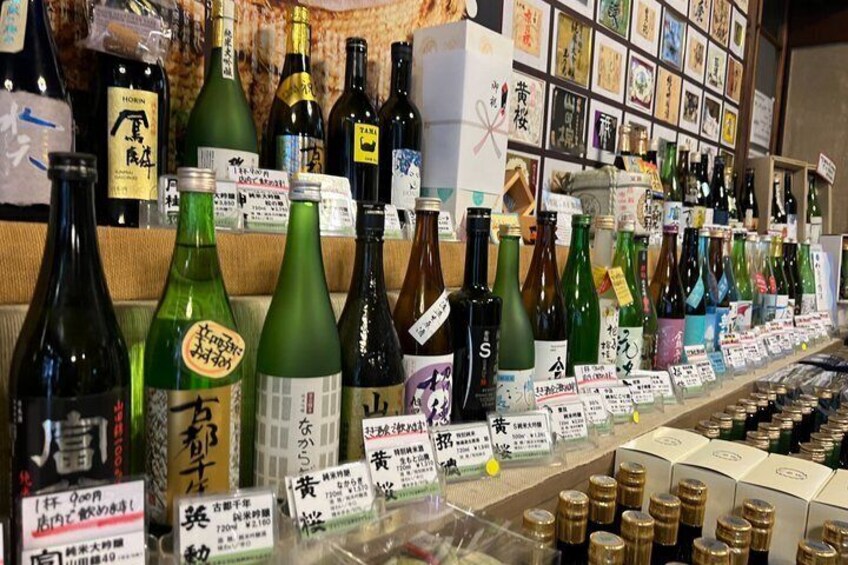 A variety of bottles and boxes, likely containing beverages or food items, with labels and price tags. 1