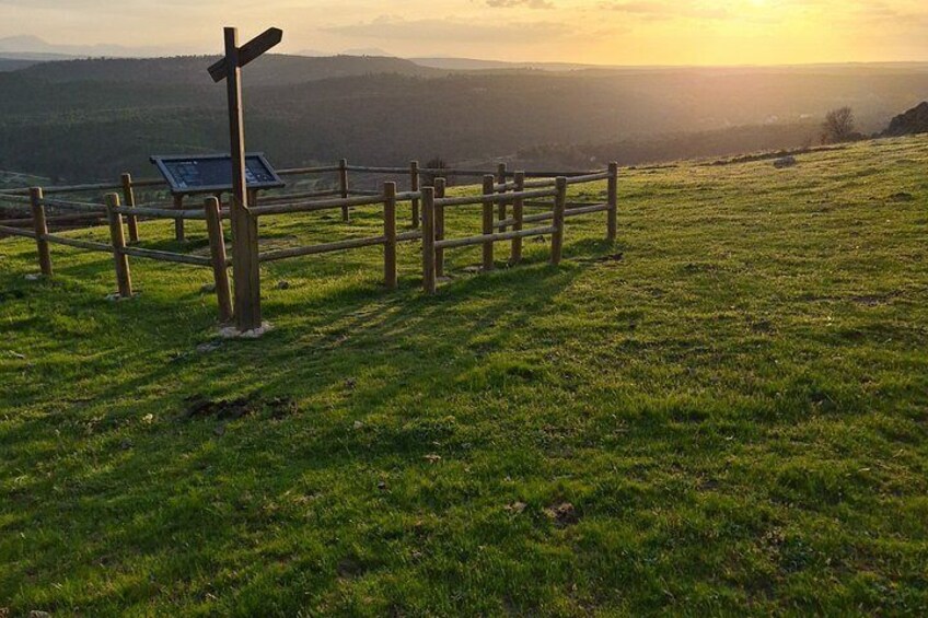 A grassy field with a wooden fence and a signpost. 3