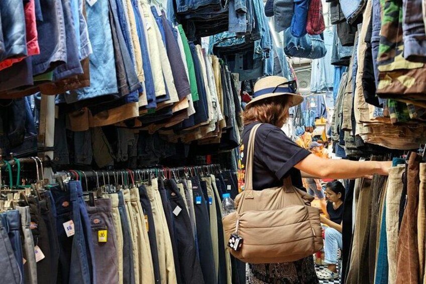 A person browsing through a clothing store with various garments on display. 2