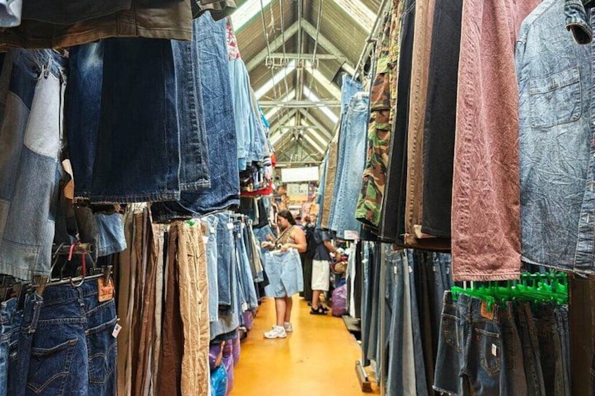 A market with denim jeans hanging on racks. 3