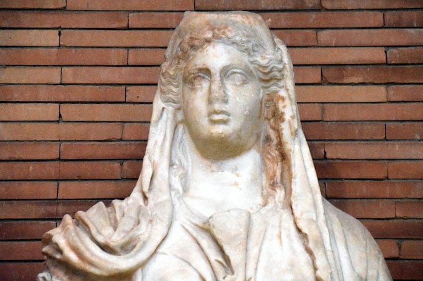A marble bust sculpture against a brick wall. 4