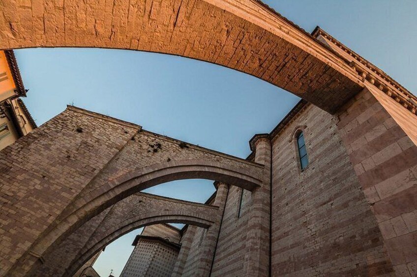 An arched stone bridge with a clear blue sky above. 2