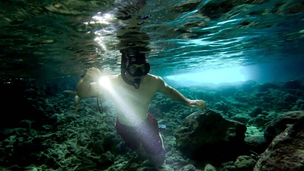 A person snorkeling underwater with sunlight filtering through the water. 5