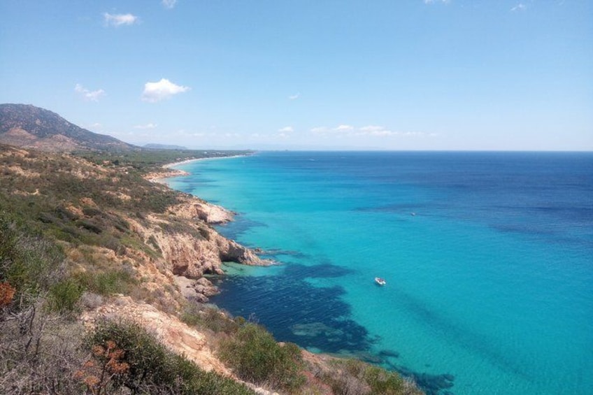 A coastal landscape with clear turquoise waters, rocky cliffs, and a distant shoreline. 4