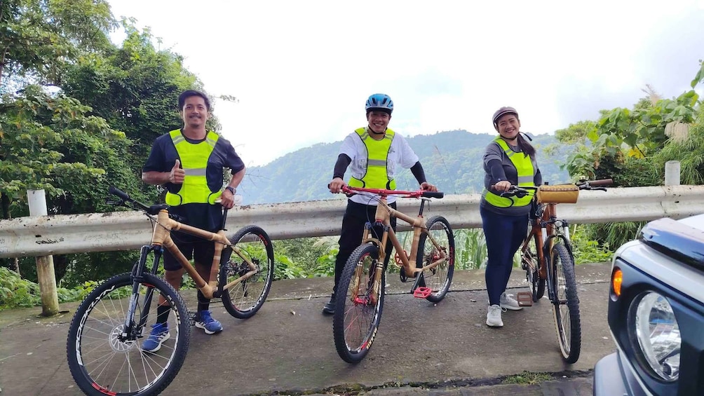 Three cyclists on a bridge with a mountainous landscape in the background. 5