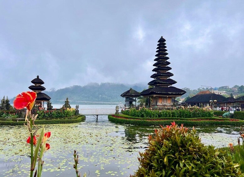 A serene landscape with a traditional pagoda, a lotus pond, and a distant view of a mountain range. 5