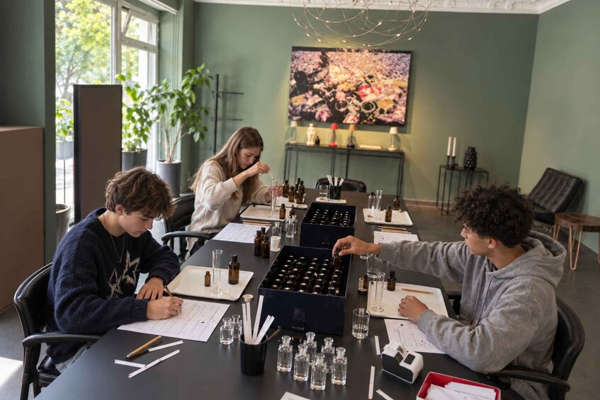 A group of people at a table with various bottles and papers, possibly conducting an experiment or tasting session. 4