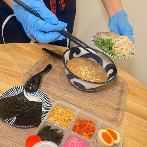 A meal with ramen, seaweed, kimchi, and other side dishes on a wooden table. 2