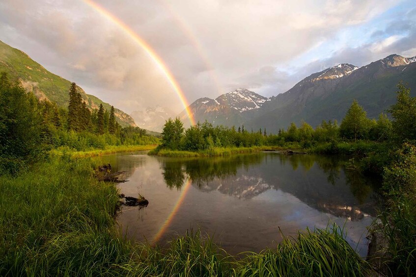 A mountain landscape with a lake reflecting a rainbow. 1