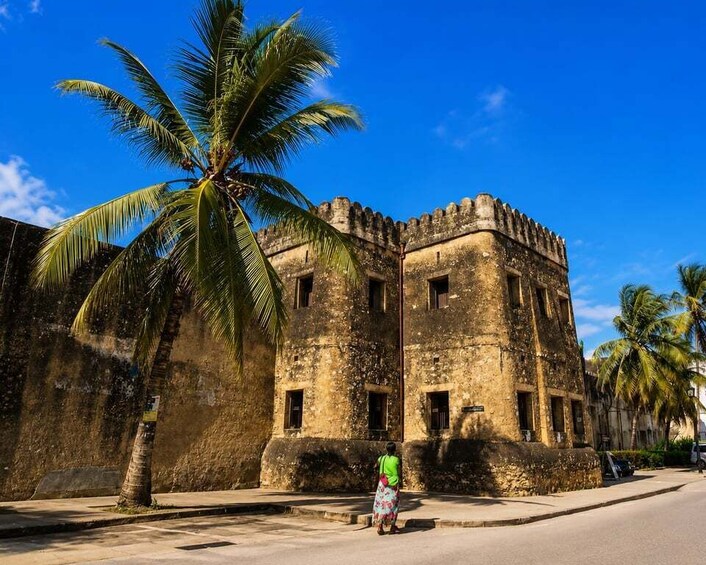 A historical building with a palm tree in front. 4