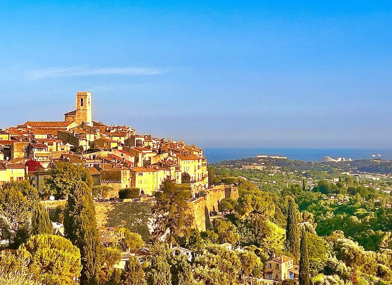 A coastal town with a prominent church tower, terraced buildings, and a view of the sea. 1
