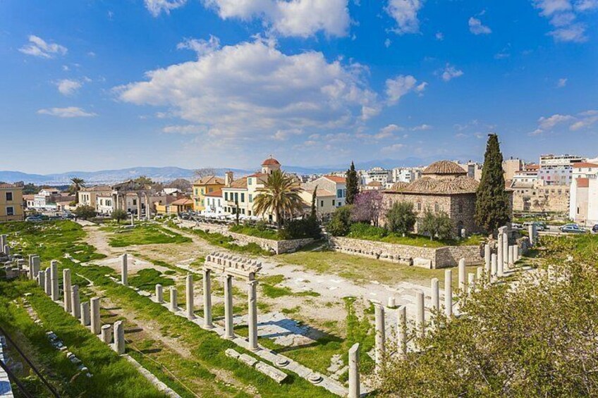 Ancient ruins with columns, a temple, and modern buildings in the background. 5