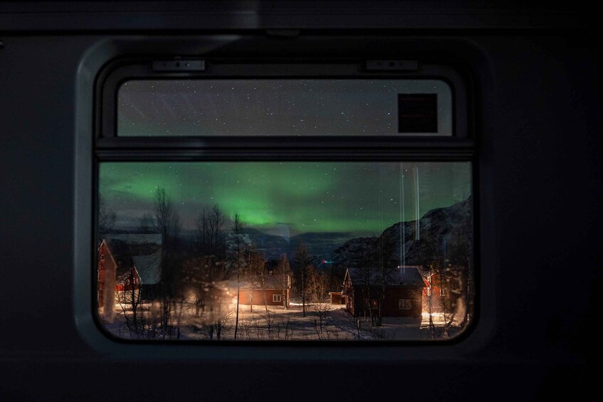 A snowy village with houses and a train window. 5