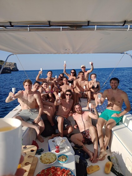 A group of people on a boat with drinks, a plate of food, and a bottle of Coca-Cola. 4