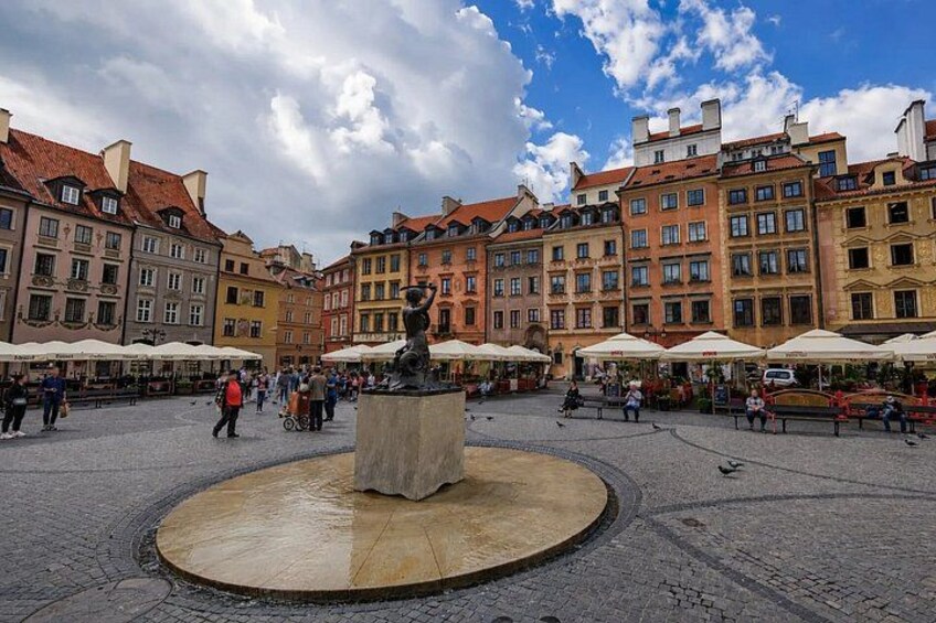 A square with a central fountain, surrounded by historic buildings and outdoor cafes. 5