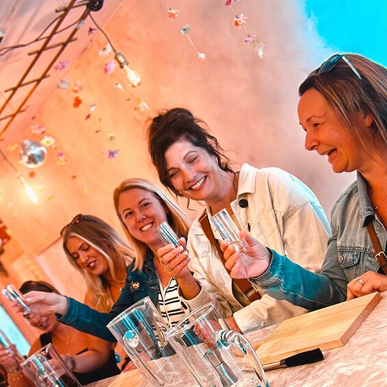 A group of people sitting at a table with drinks, surrounded by a festive atmosphere with hanging decorations. 1