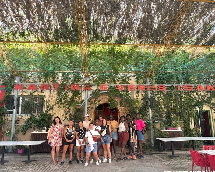 A group of people standing in front of a restaurant with a sign that reads 'REVERES'. 2