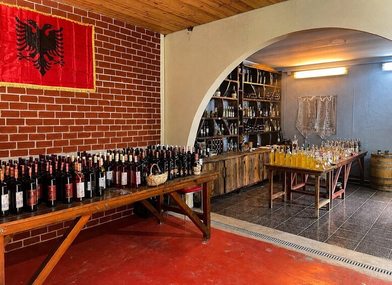 A wine cellar with a brick wall, a wooden table with wine bottles, and a wooden archway. 5