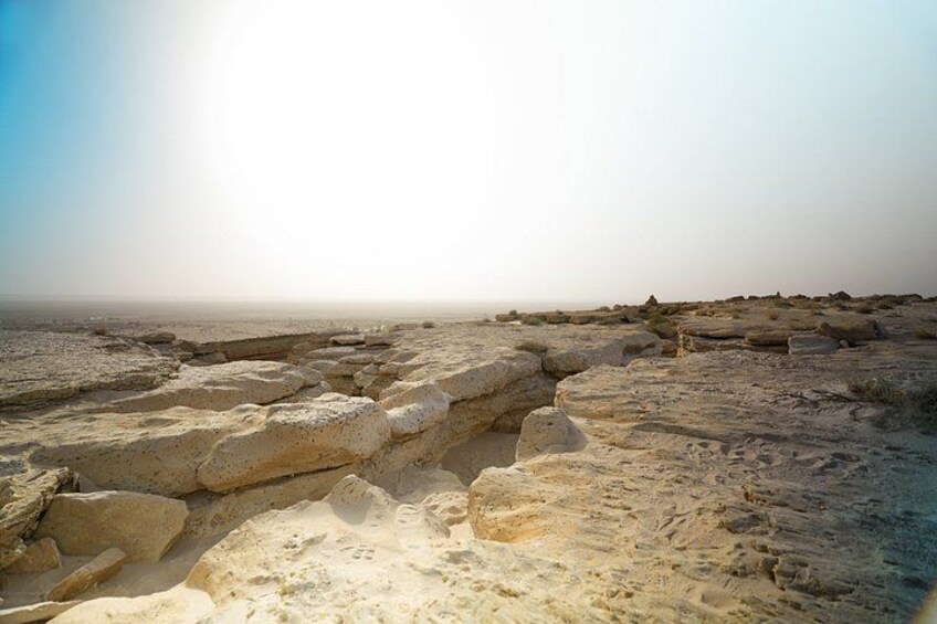 A desert landscape with large rock formations and a clear sky. 3