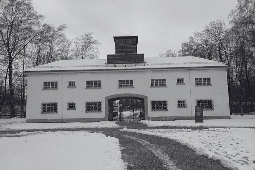 A snow-covered building with a central entrance, surrounded by bare trees. 1
