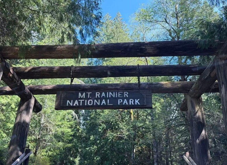 A wooden sign reading 'MT. RAINIER NATIONAL PARK' amidst a forest. 3