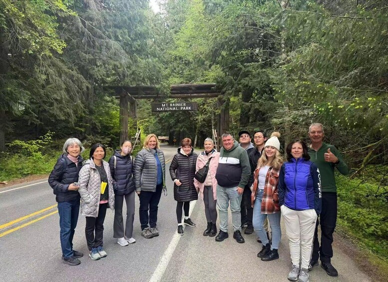 A group of people standing in front of a sign that reads 'Mt. Rainier National Park.' 5