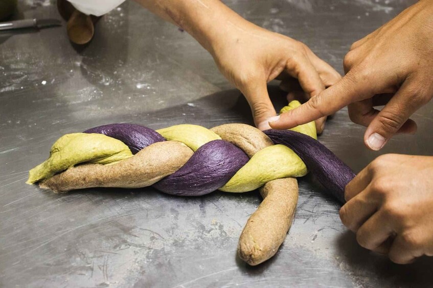 Manos trenzando una cuerda colorida. 2