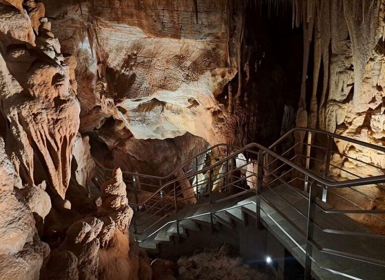 A cave with stalactites and a metal staircase. 2