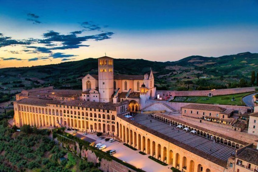 A historic building with a prominent tower, arched walkways, and a surrounding courtyard. 1